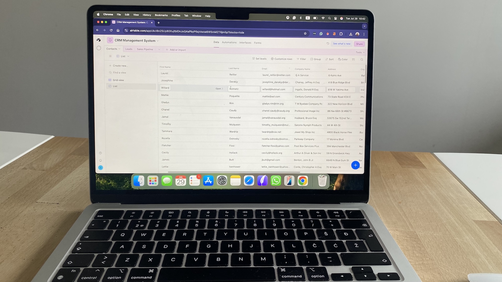 Airtable CRM contact management table view showing names, emails, companies, and addresses in a spreadsheet-style layout.
