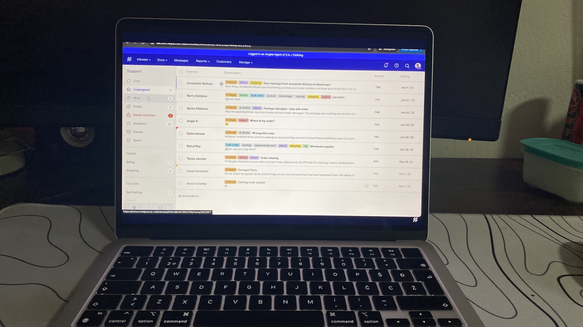 Help Scout inbox view on laptop showing support emails, customer names, and message status for handling requests.
