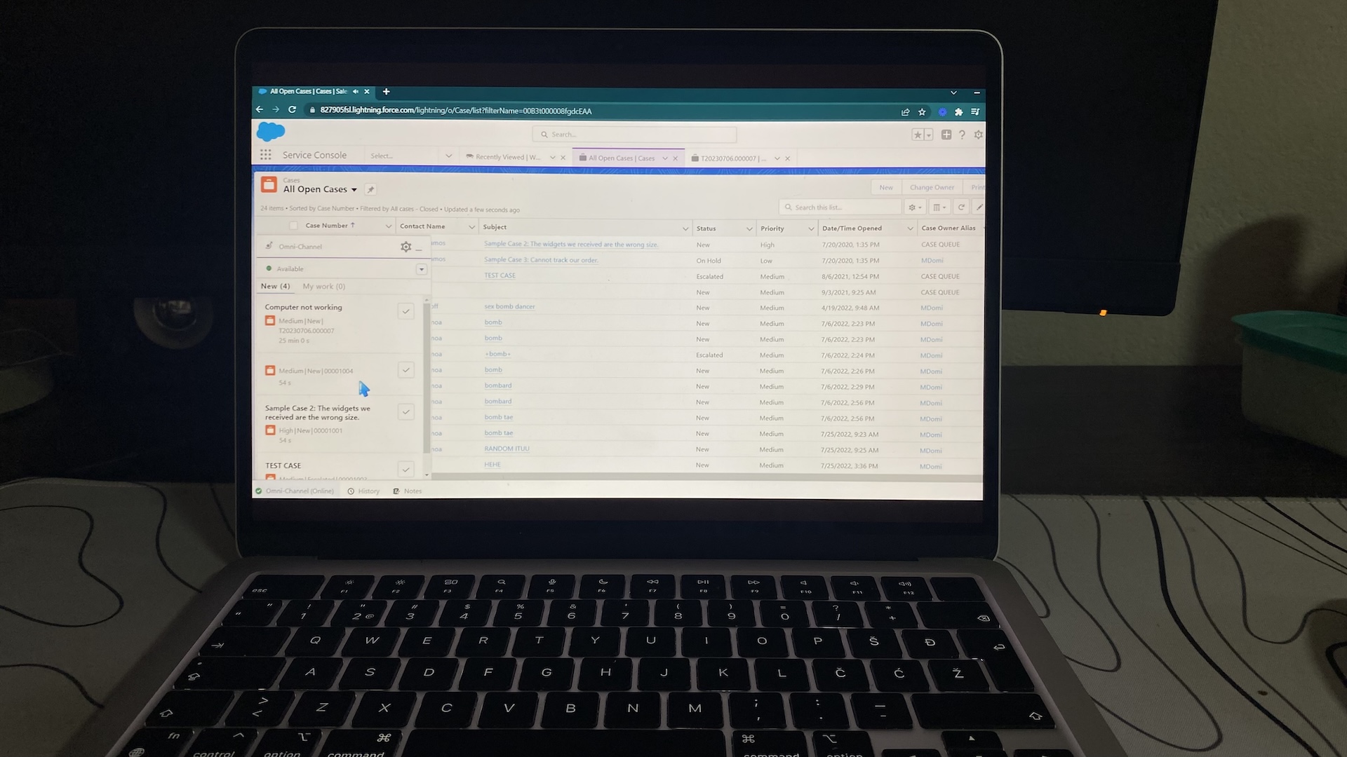 Salesforce Service Cloud console on laptop with open cases list, showing customer issues, statuses, and priorities.